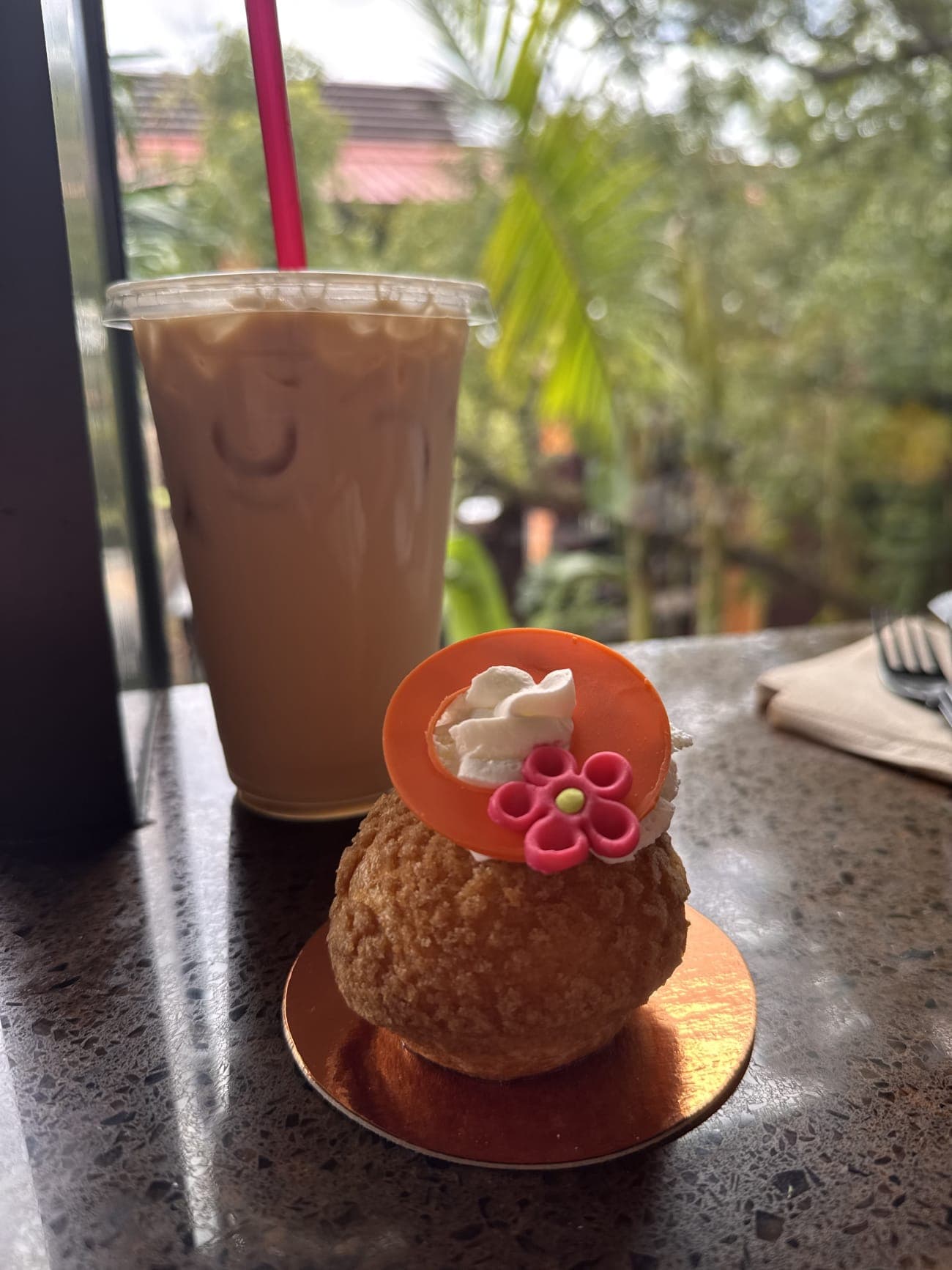 Coconut-pineapple choux and iced Joffrey's coffee overlooking Polynesian Village Resort grounds