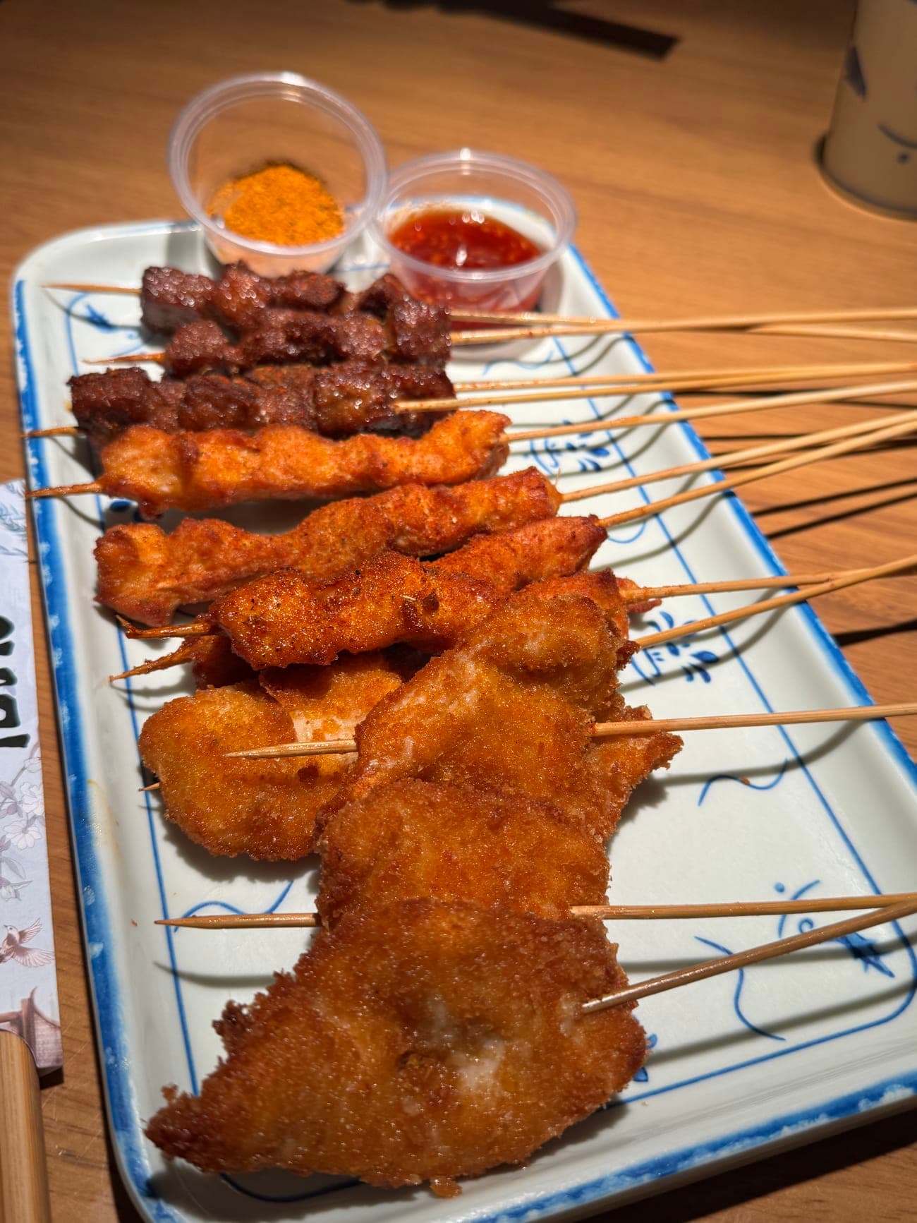 Platter of fried beef chicken and crispy chicken skewers with cumin powder and sweet chili sauce at SLAP Hand-Ripped Noodles