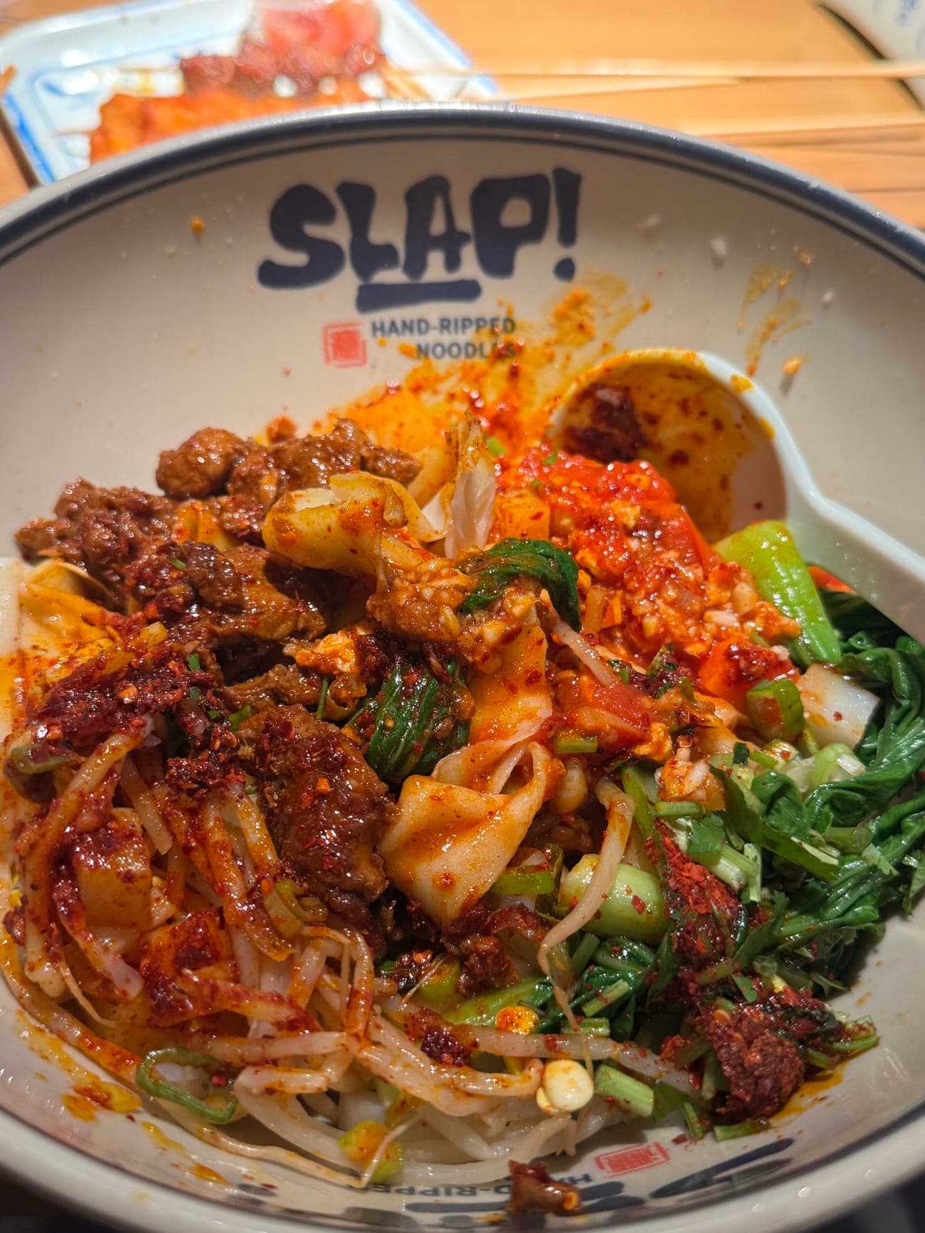 Signature three way slap noodles with sliced pork tomato and egg and vegetables in a SLAP bowl