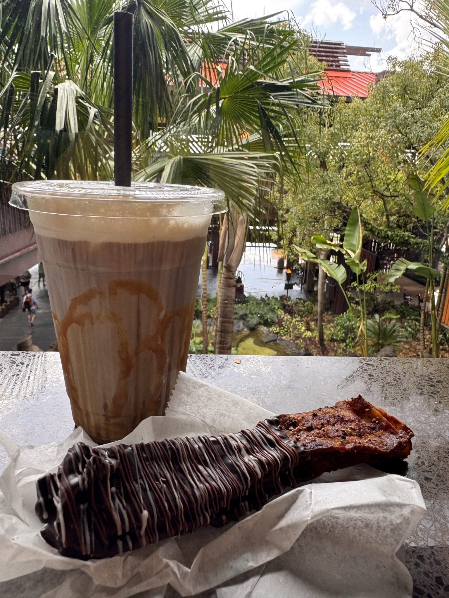 Chocolate-covered bacon and iced caramel macchiato with the Polynesian lobby atrium behind