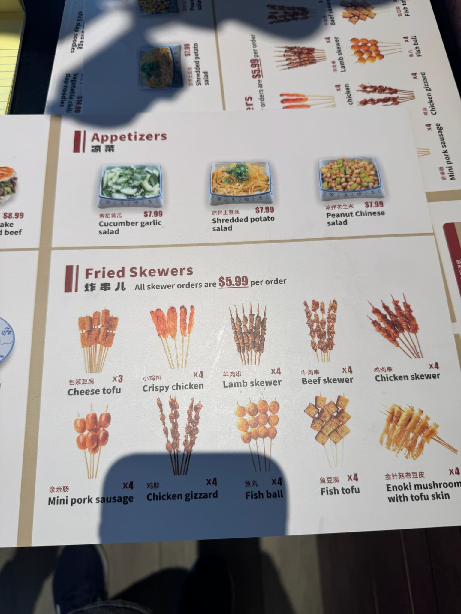 SLAP Hand-Ripped Noodles paper menu showing appetizer salads and fried skewers with prices