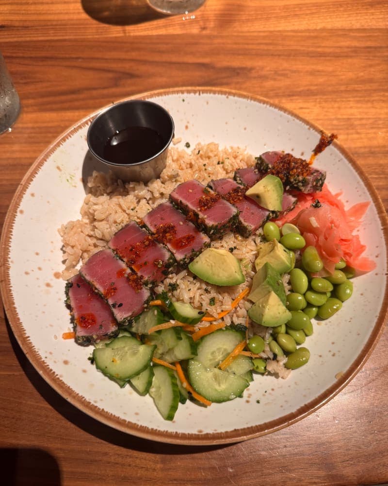 Seared rare chili crunch ahi tuna over furikake-seasoned rice with edamame, avocado, marinated cucumbers, pickled ginger, and citrus soy dipping sauce